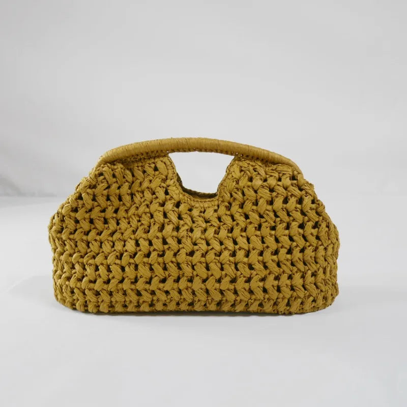 Brown woven straw handbag with top handle on light backdrop