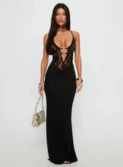 Woman wearing a black lace bodysuit with a plain background