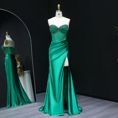 Green evening gown on a mannequin against a black background