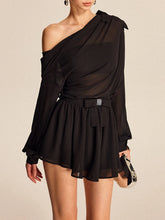 Black one-shoulder dress worn by a model on a beige background