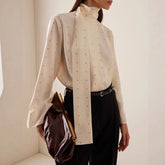 Polka dot high neck blouse with trailing scarf detail and bell sleeves