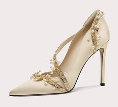 Beige high-heeled shoe with floral embellishments on a white background