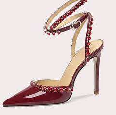 Red high-heeled shoe with decorative straps on a white background