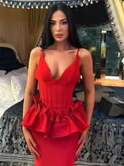Woman wearing a red dress with peplum details in an elegant room.
