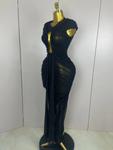 Black evening gown on a mannequin against a white background