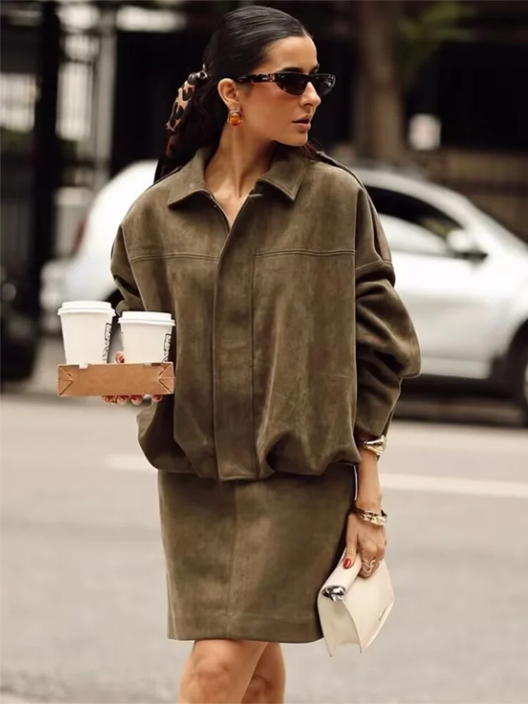 Woman in a brown dress holding coffee cups on a city street