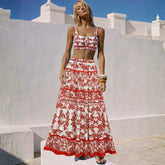 Woman wearing a red and white printed strappy crop top and tiered maxi skirt.