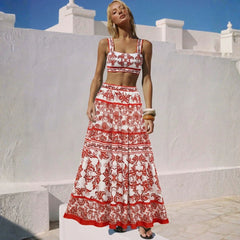 Woman wearing a red and white printed strappy crop top and tiered maxi skirt.