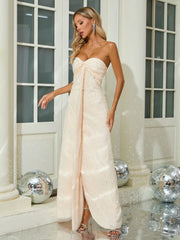 Woman in a strapless white gown standing in a decorated room with disco balls.
