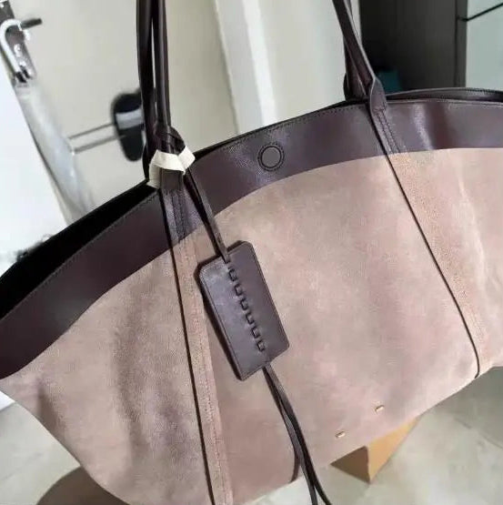 Brown tote bag with a strap and tag on a blurred background