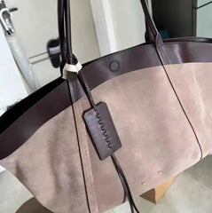 Brown tote bag with a strap and tag on a blurred background