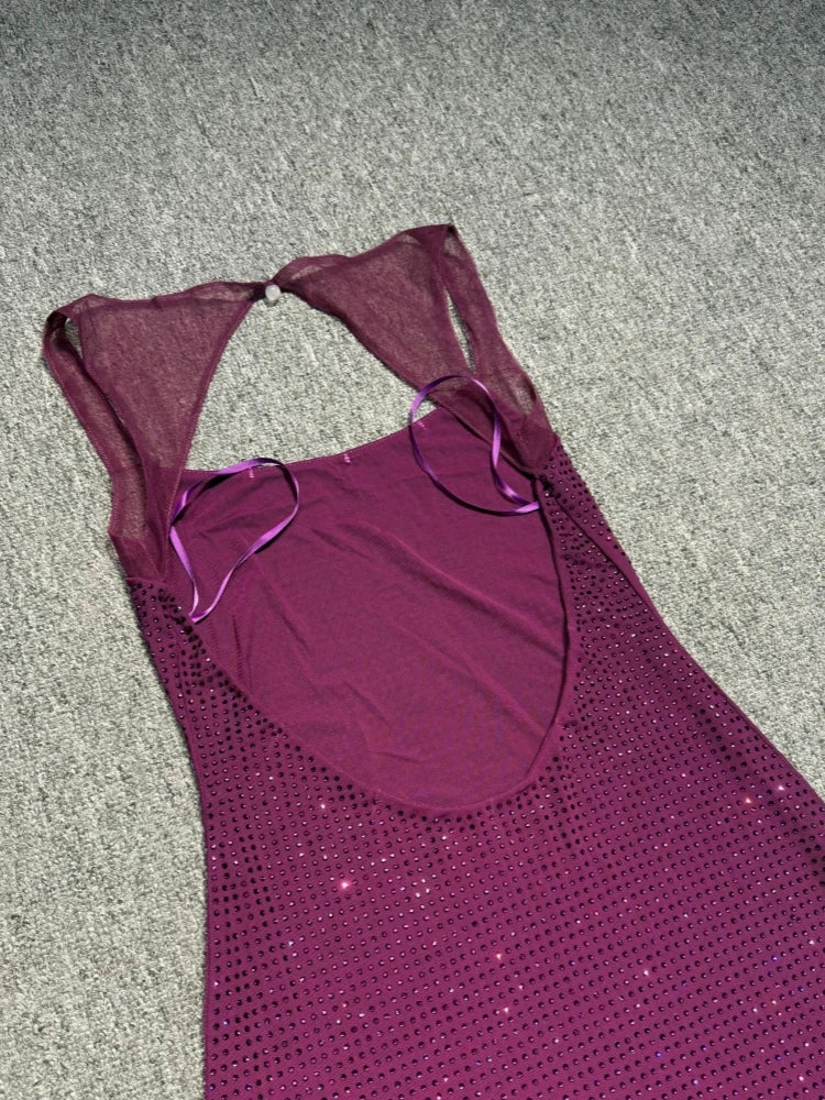 Purple swimsuit with cut-out design on a gray surface
