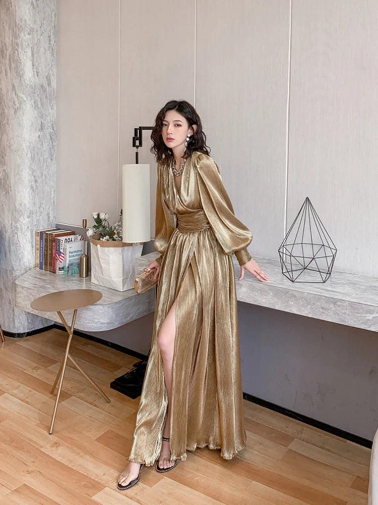 Woman in a gold dress standing in a modern interior setting