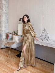 Woman in a gold dress standing in a modern interior setting