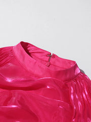 Close-up of a bright pink dress with a plain background
