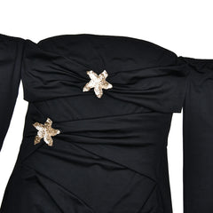 Black dress with star-shaped embellishments on a white background