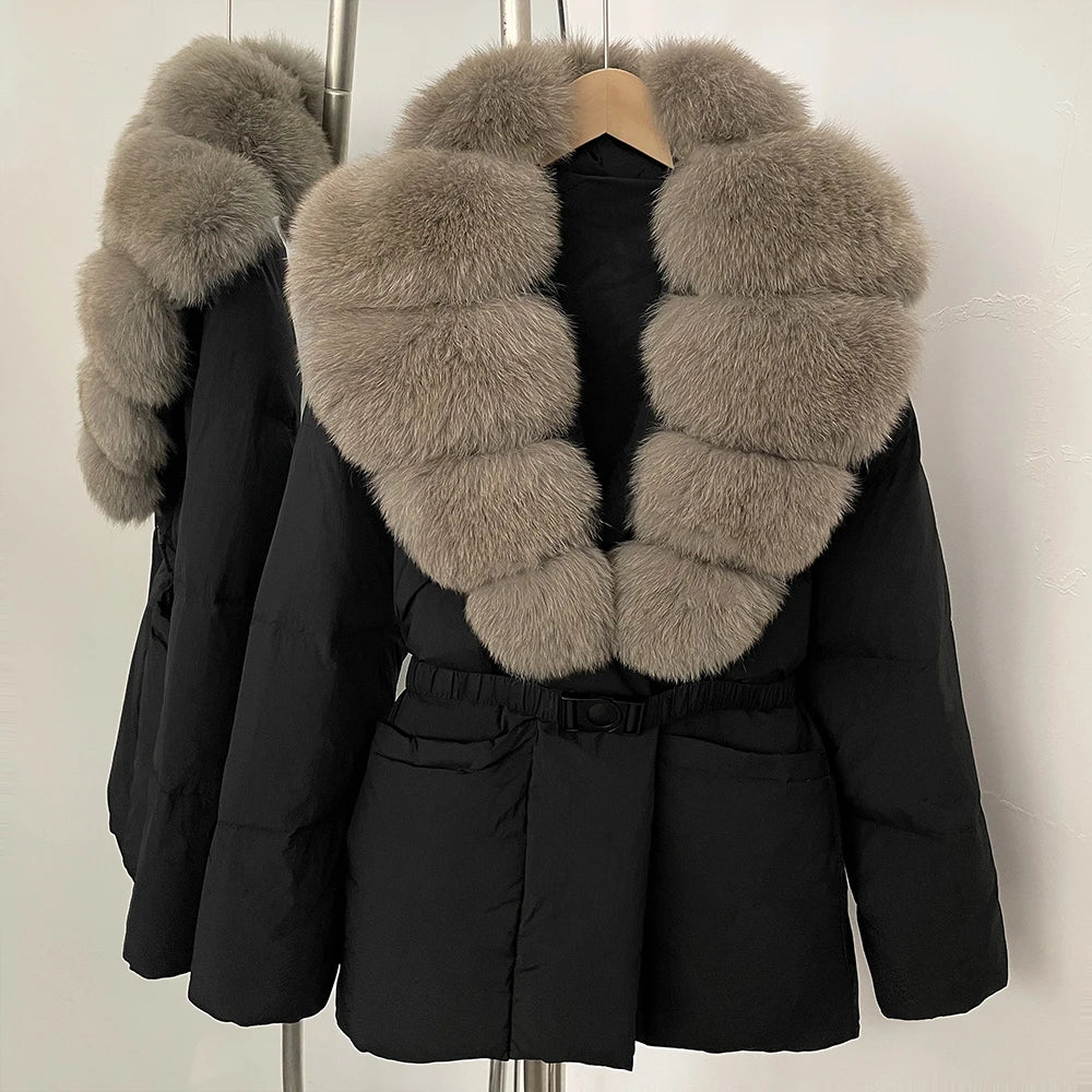 Black puffer jacket with fur collar on a hanger against a white background