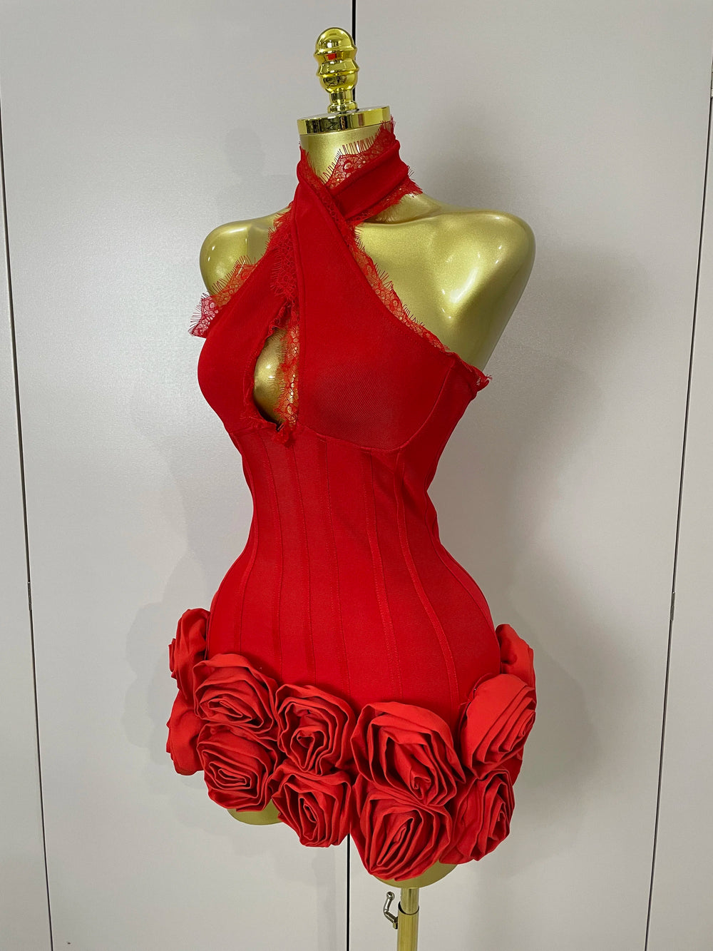 Red dress with floral details on a mannequin against a white background