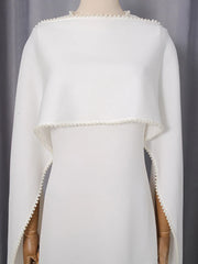 White cape with pearl trim on a mannequin against a gray background