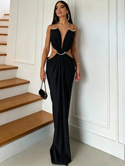 Woman wearing a black halter neck draped maxi dress next to stairs