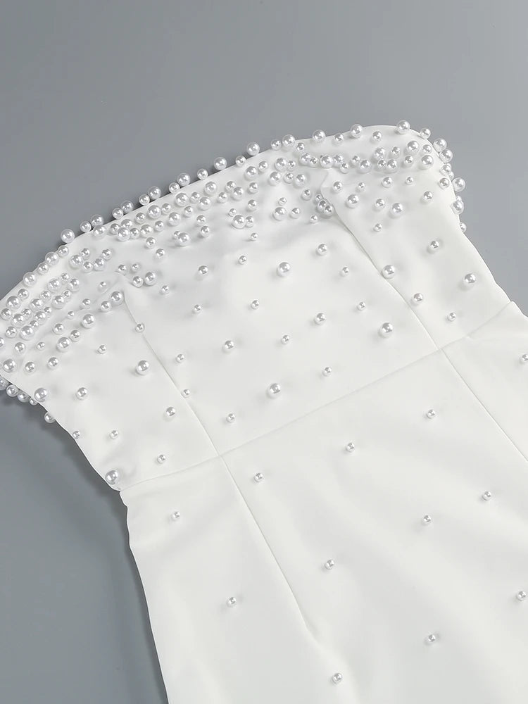 White fabric with pearl embellishments on a gray background