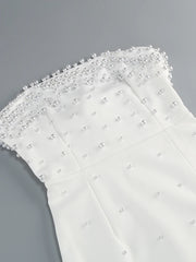 White fabric with pearl embellishments on a gray background