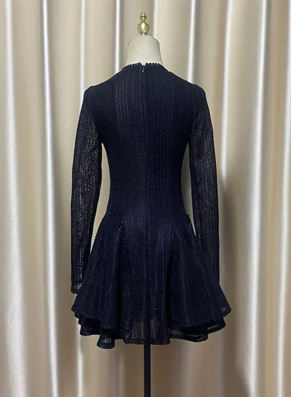 Navy blue dress on a mannequin against a beige curtain background