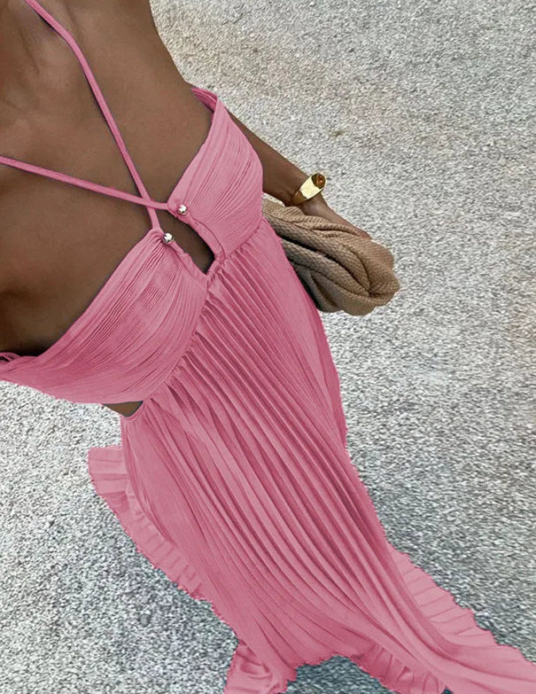 Pink pleated dress worn by a person on a textured gray background