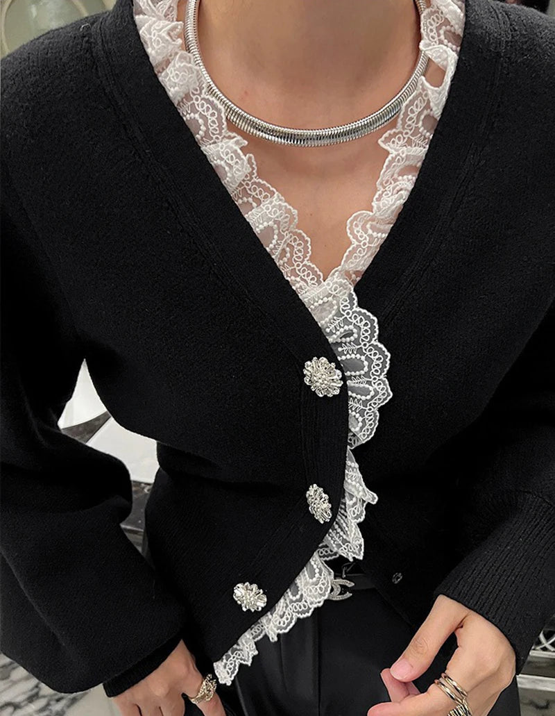 Black cardigan with white lace detailing on a blurred indoor background