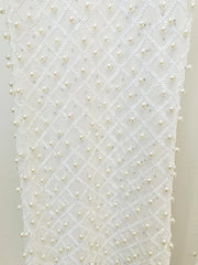 White fabric with a pattern of small pearls on a plain background