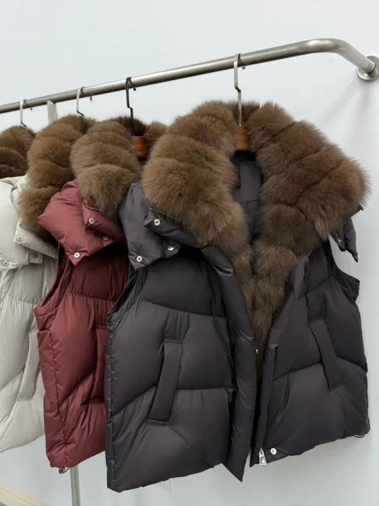 Black puffer jacket with brown fur hood on a rack against a white background