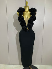 Black evening gown with floral details on a mannequin against a plain background