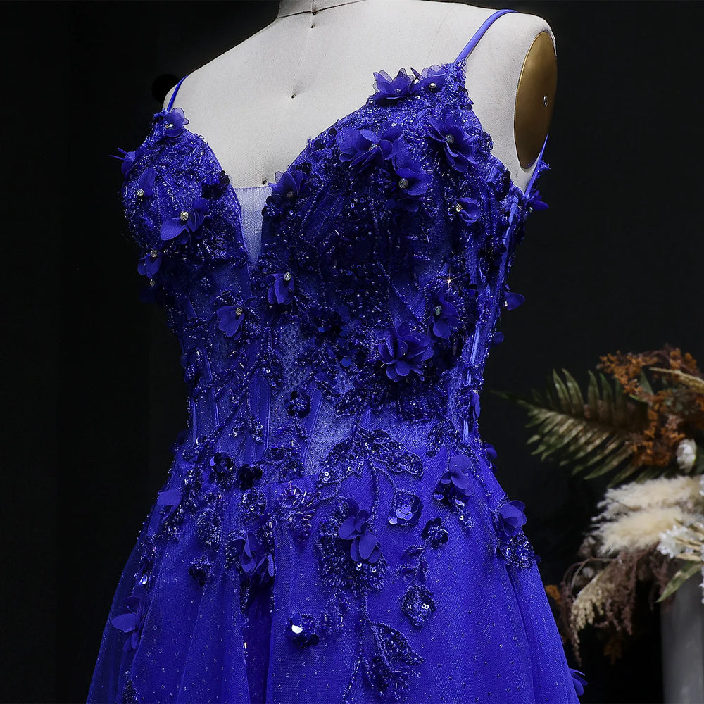 Blue evening gown with floral embellishments on a mannequin against a dark background