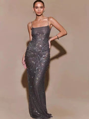 Woman wearing a sparkly silver evening gown against a beige background