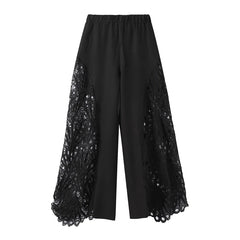 Black pants with lace detailing on a white background