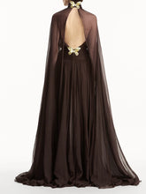 Brown evening gown with cape and floral back design on a white background
