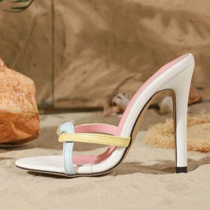 Close-up of multi-strap stiletto heels on sand