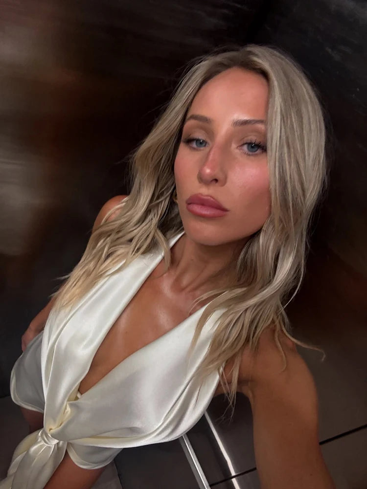 Woman wearing a white satin dress against a dark background