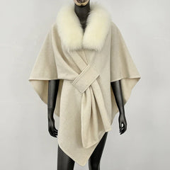 Cream knit poncho with a white fur collar and knotted front.