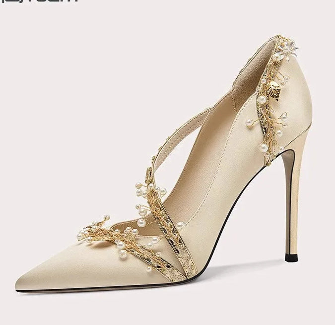 Beige high-heeled shoe with floral embellishments on a white background