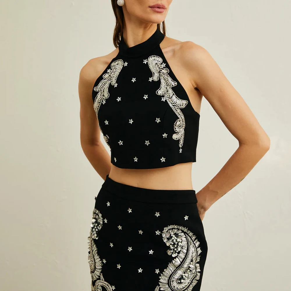 Black halter top with silver embroidery on a neutral background