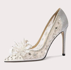 Silver high-heeled shoe with floral design on a white background