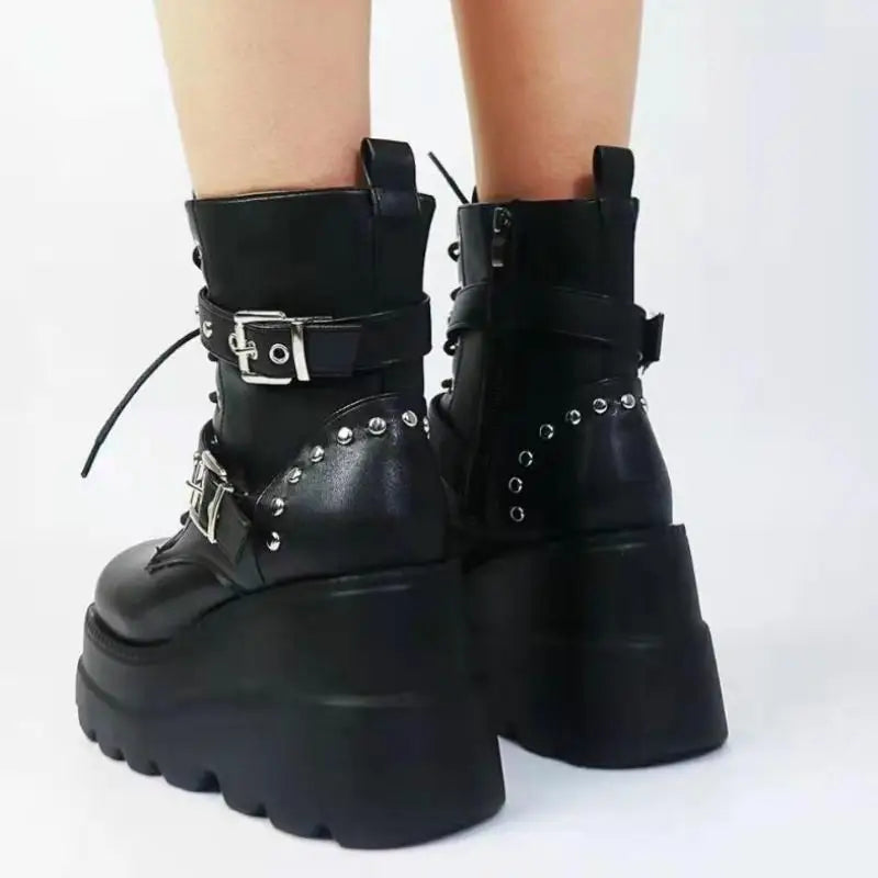 Black platform boots with buckles and studs on a white background
