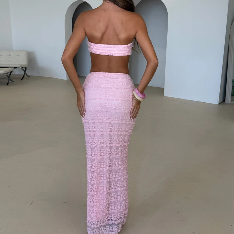 Person wearing a pink strapless dress with a high slit in a minimal indoor setting