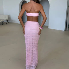 Person wearing a pink strapless dress with a high slit in a minimal indoor setting