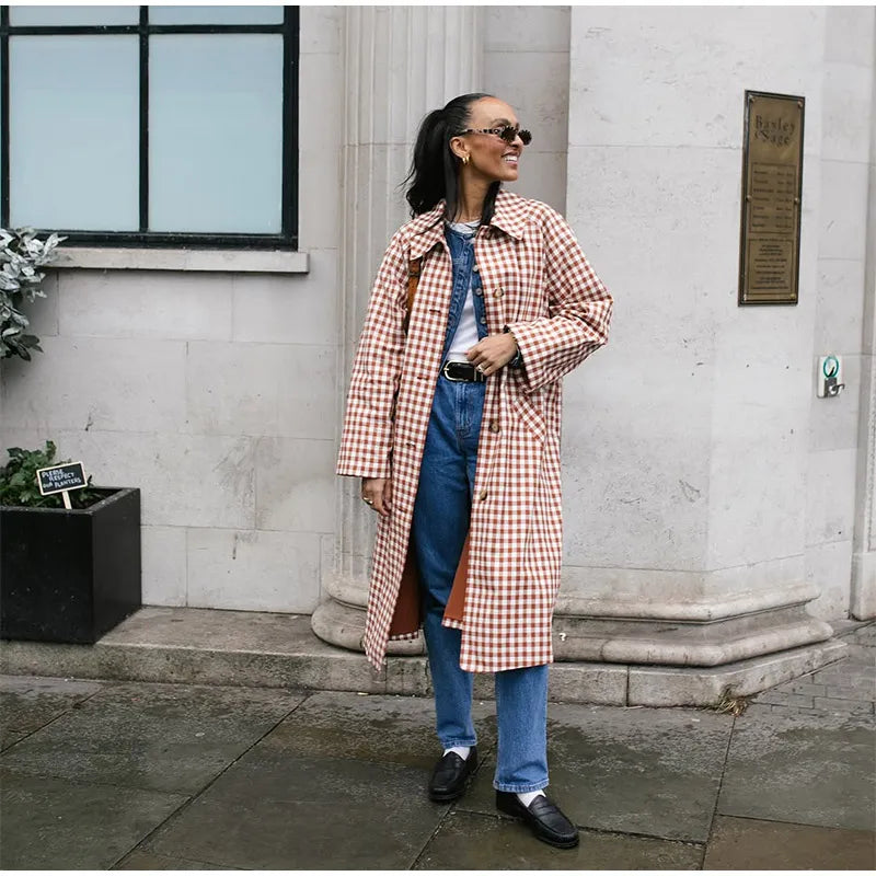 Woman wearing a plaid coat standing outside a building