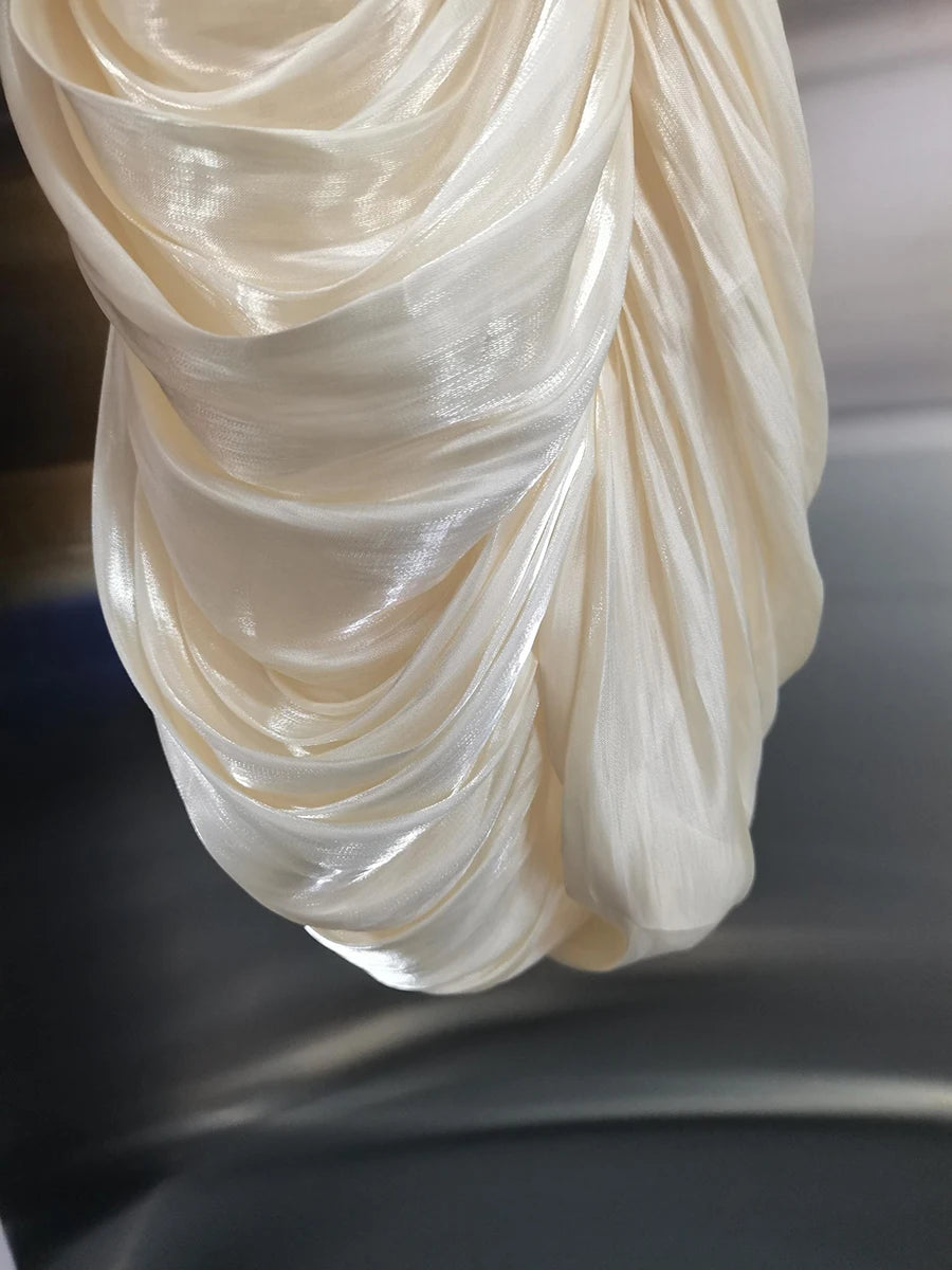 Close-up of a draped white fabric on a dark background