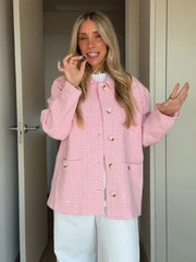 Woman wearing a pink checkered jacket indoors