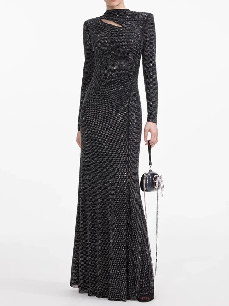 Black sequin evening gown with long sleeves on a white background