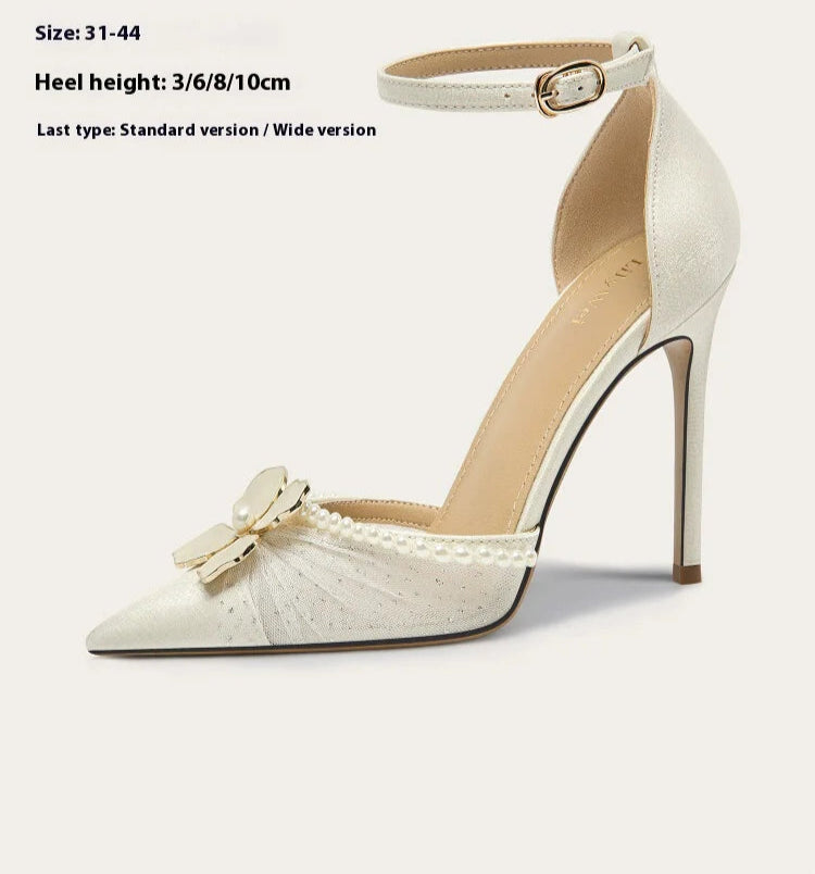 White high-heeled shoe with bow detail on a white background,